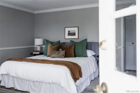 a bedroom with a bed and a painting on the wall
