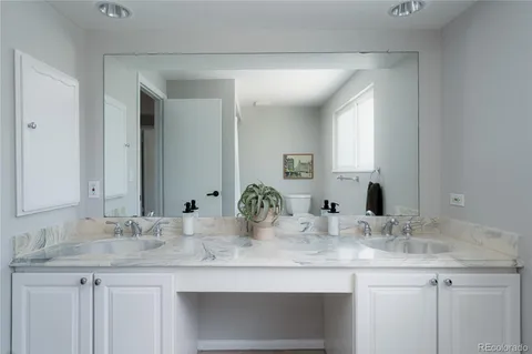 a bathroom with double sink and a mirror