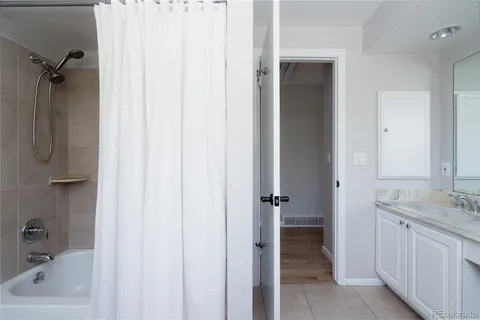 a bathroom with a tub shower vanity and a sink