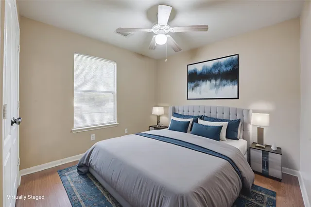 an empty room with wooden floor and ceiling fan