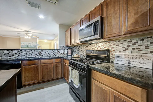 a kitchen with granite countertop cabinets stainless steel appliances and a sink