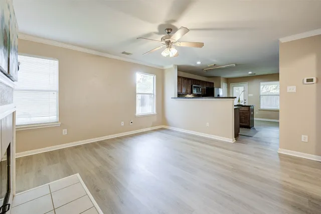 a view of a livingroom with a stove wooden cabinets and chandelier