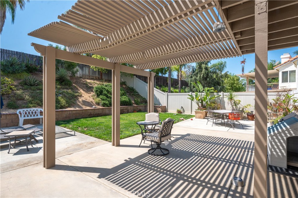 19465 Kinnow Lane Riverside, CA 92508 - Photo 39 of 61 a view of a patio with dining table and chairs with wooden floor and fence