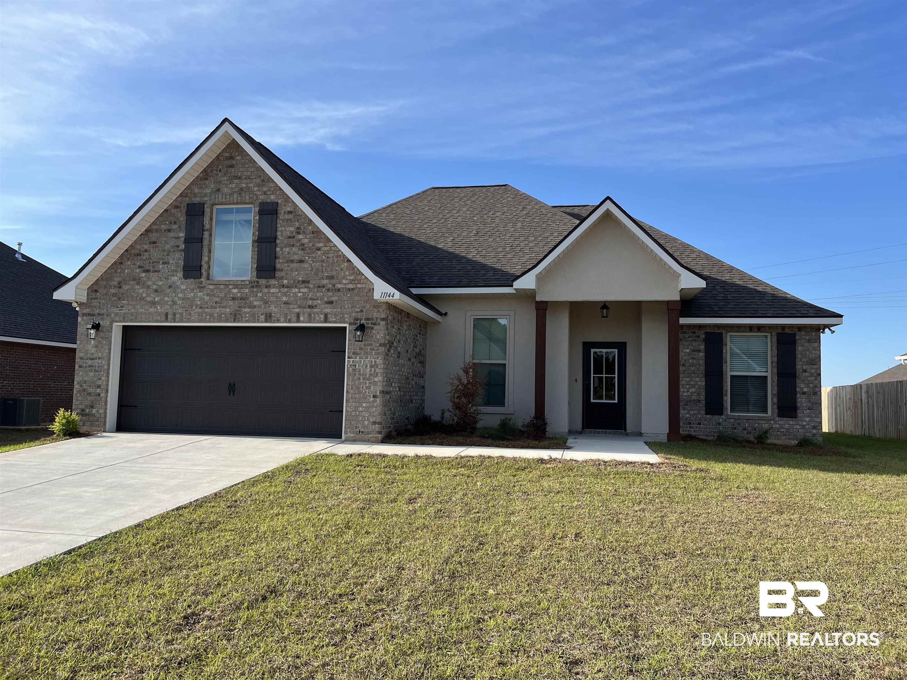 11144 Bonaventure Avenue Daphne, AL 36526 - Photo 1 of 3 View of front of house featuring brick siding, driveway, a shingled roof, and covered porch