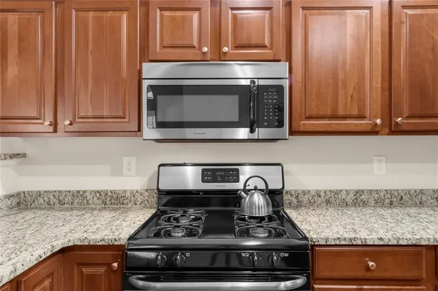 a kitchen with granite countertop a stove and a microwave
