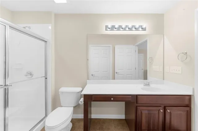 a bathroom with a sink a toilet a mirror and shower