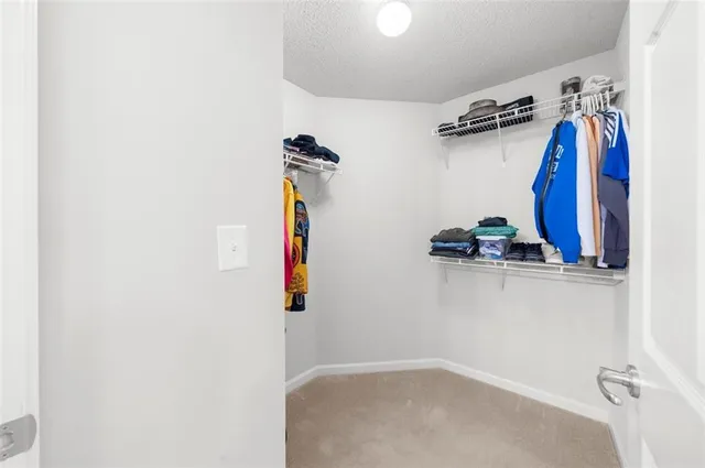 a view of walk in closet with clothes