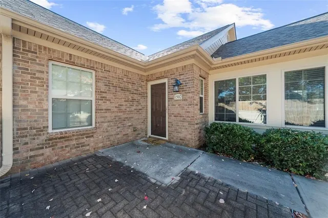 front view of a brick house with a yard