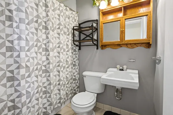 a bathroom with a sink a toilet and a mirror