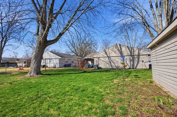 a view of backyard with large trees and a barn
