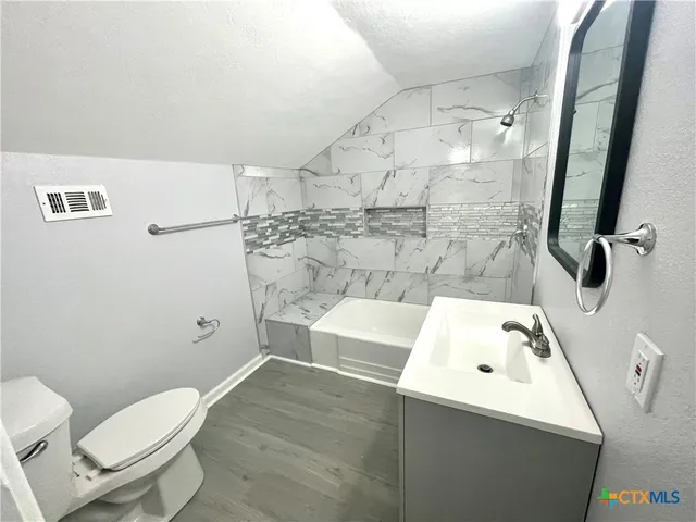 a bathroom with a sink toilet and shower