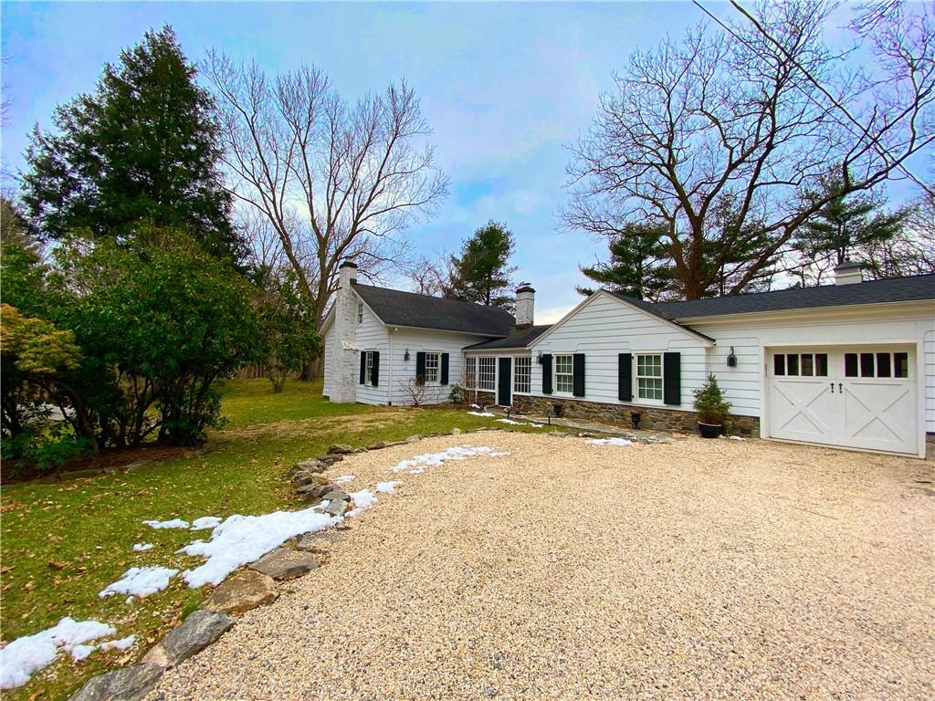 a front view of a house with a yard covered with trees