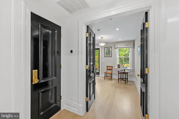 a view of a hallway with furniture and a window