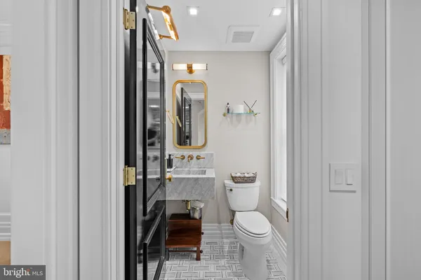 a bathroom with a toilet a sink and mirror