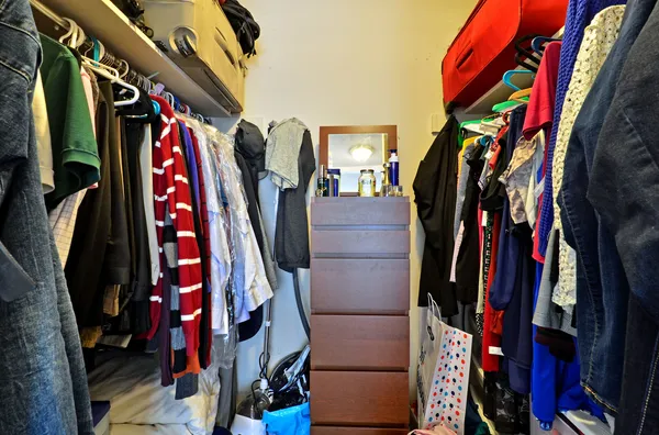 a view of walk in closet with clothes and shoes