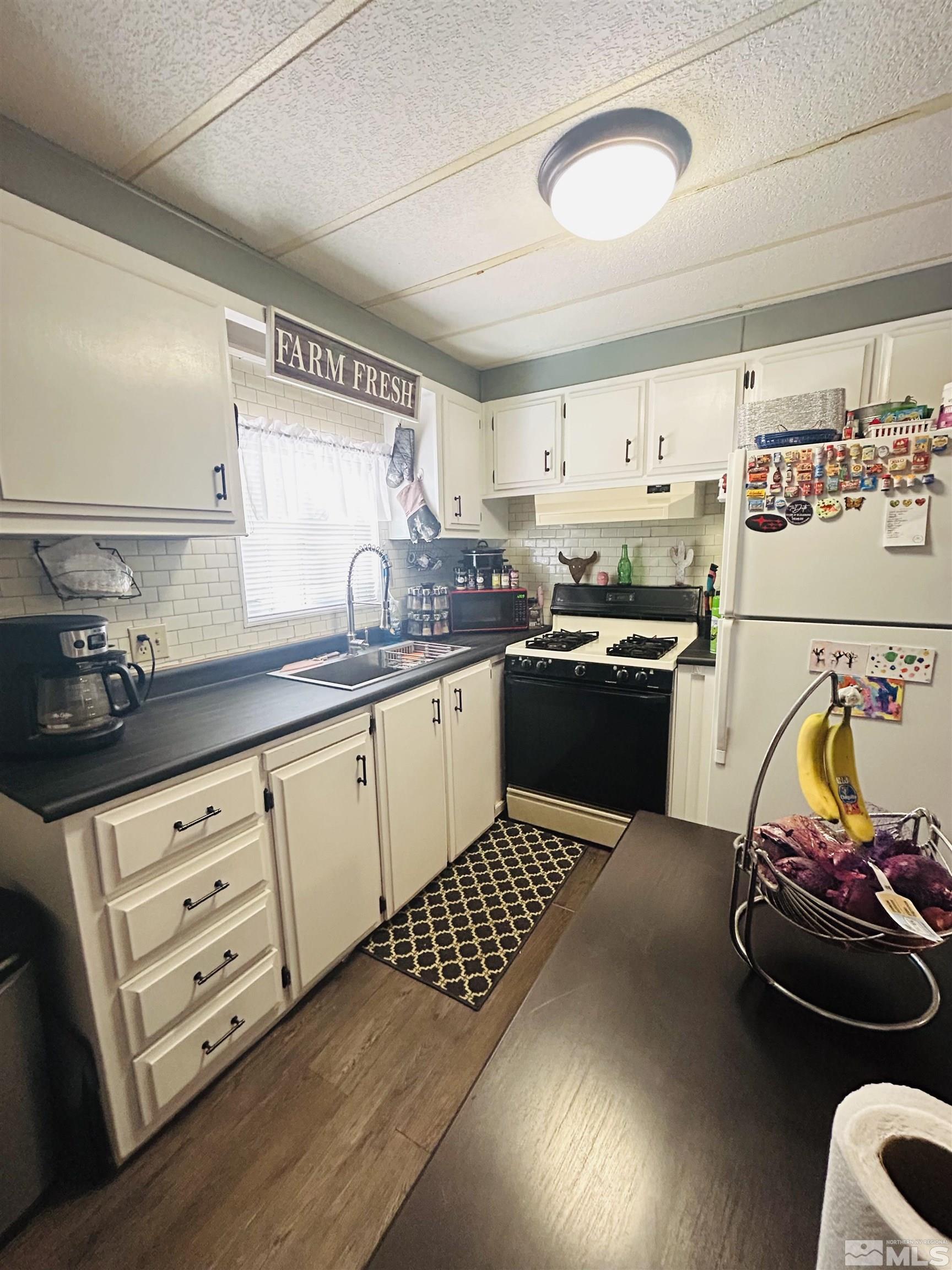 212 Coons Circle, Unit E Dayton, NV 89403 - Photo 5 of 20 a kitchen with granite countertop a sink cabinets stainless steel appliances and a window