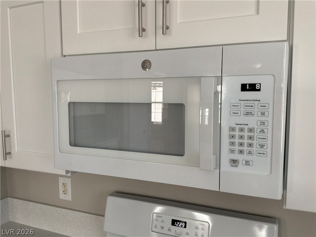 9041 Rendon Street Las Vegas, NV 89143 - Photo 27 of 34 An over-the-range microwave sits integrated amongst shaker cabinetry in this updated culinary space.