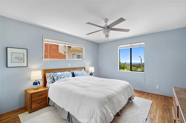 a bedroom with a large bed and wooden floor