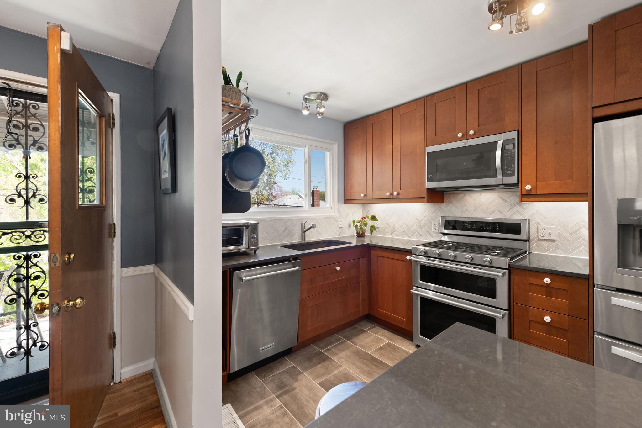 716 Delafield Street Northeast Washington, DC 20017 - Photo 10 of 32 a kitchen with stainless steel appliances granite countertop a stove top oven a sink and dishwasher