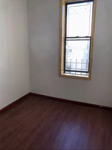 an empty room with wooden floor and a window