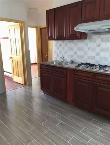 a kitchen with granite countertop wooden cabinets a sink and a stove