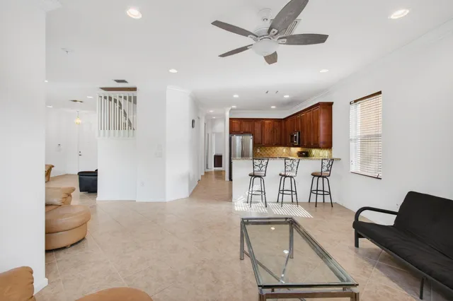 a view of a livingroom with entryway stairs and windows