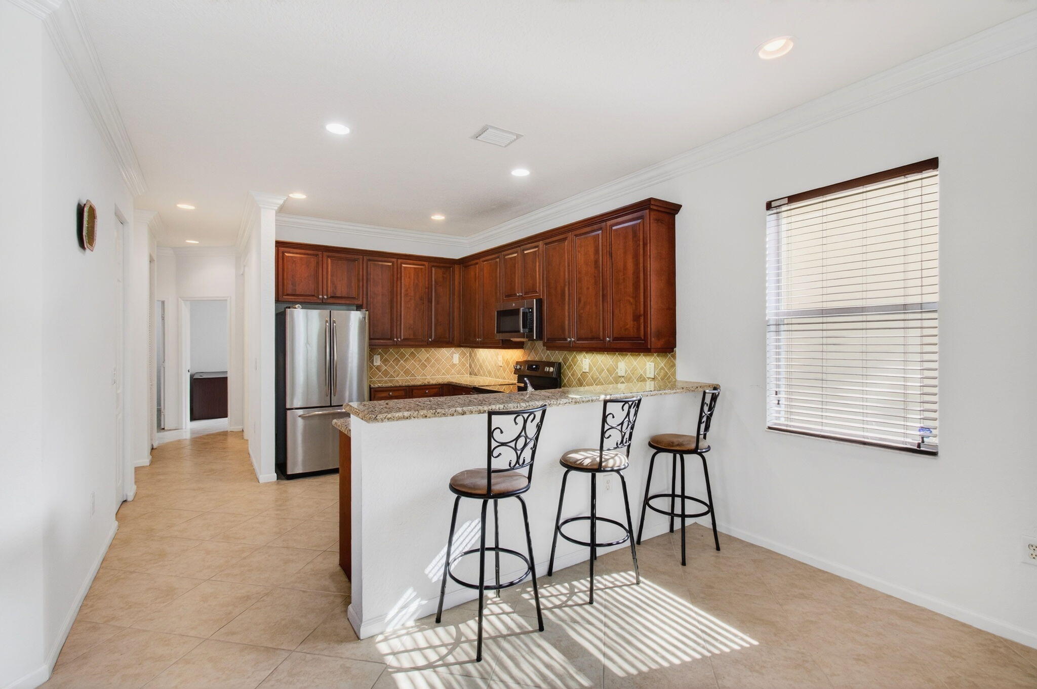 7533 Topiary Avenue Boynton Beach, FL 33437 - Photo 21 of 90 a kitchen with stainless steel appliances kitchen island granite countertop a refrigerator and a stove top oven