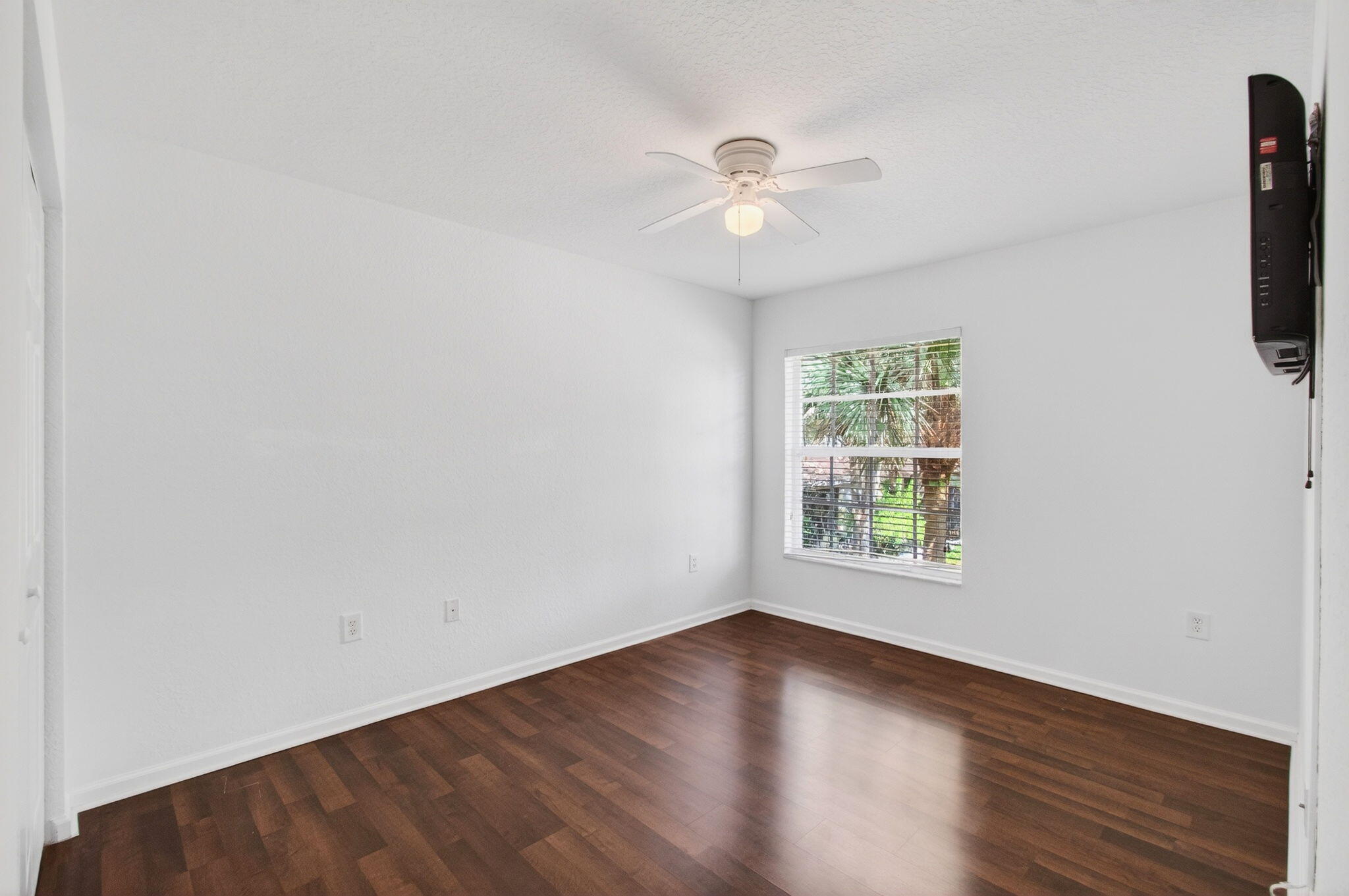 7533 Topiary Avenue Boynton Beach, FL 33437 - Photo 50 of 90 an empty room with wooden floor fan and windows