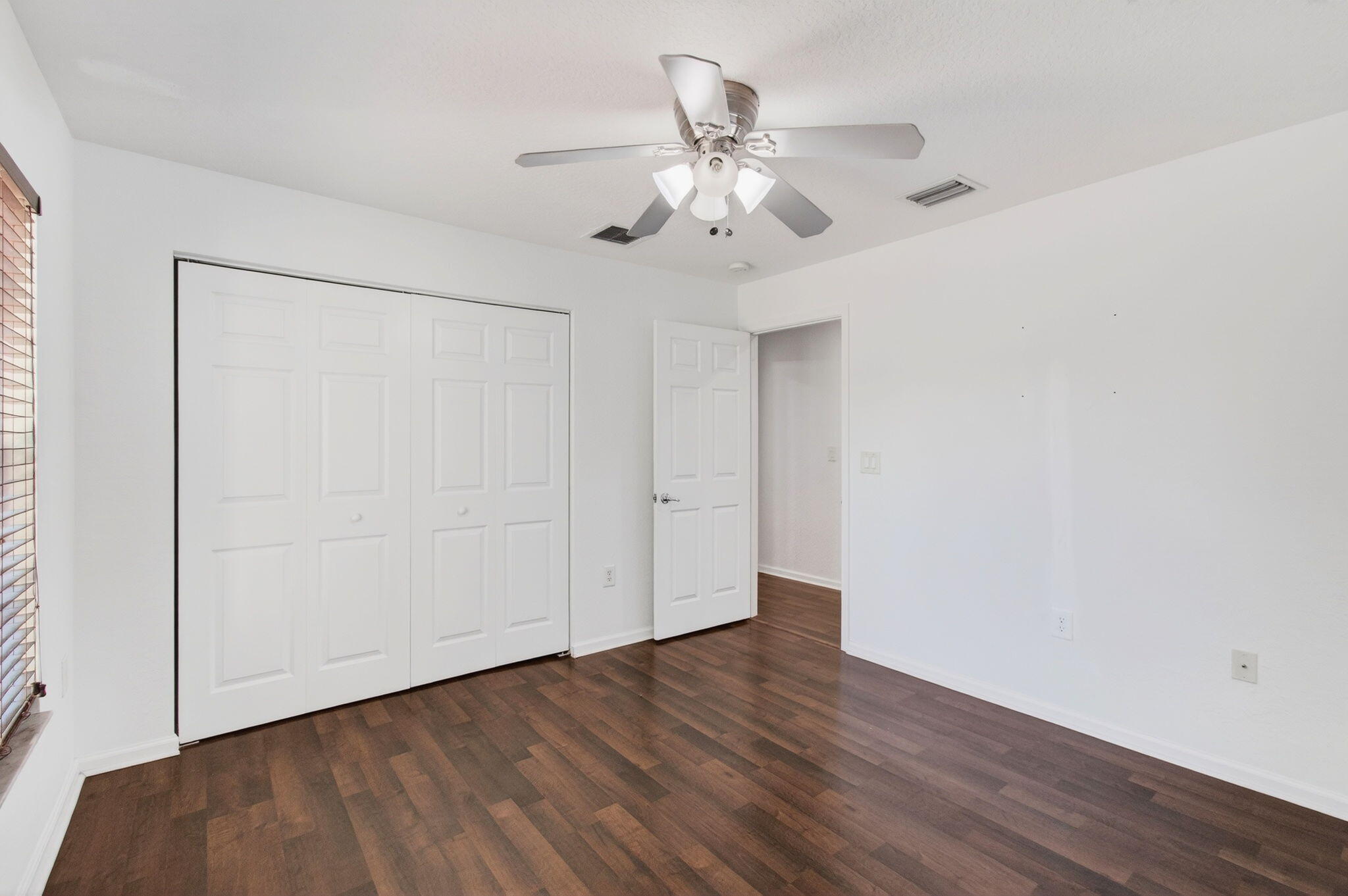7533 Topiary Avenue Boynton Beach, FL 33437 - Photo 55 of 90 an empty room with wooden floor fan and windows