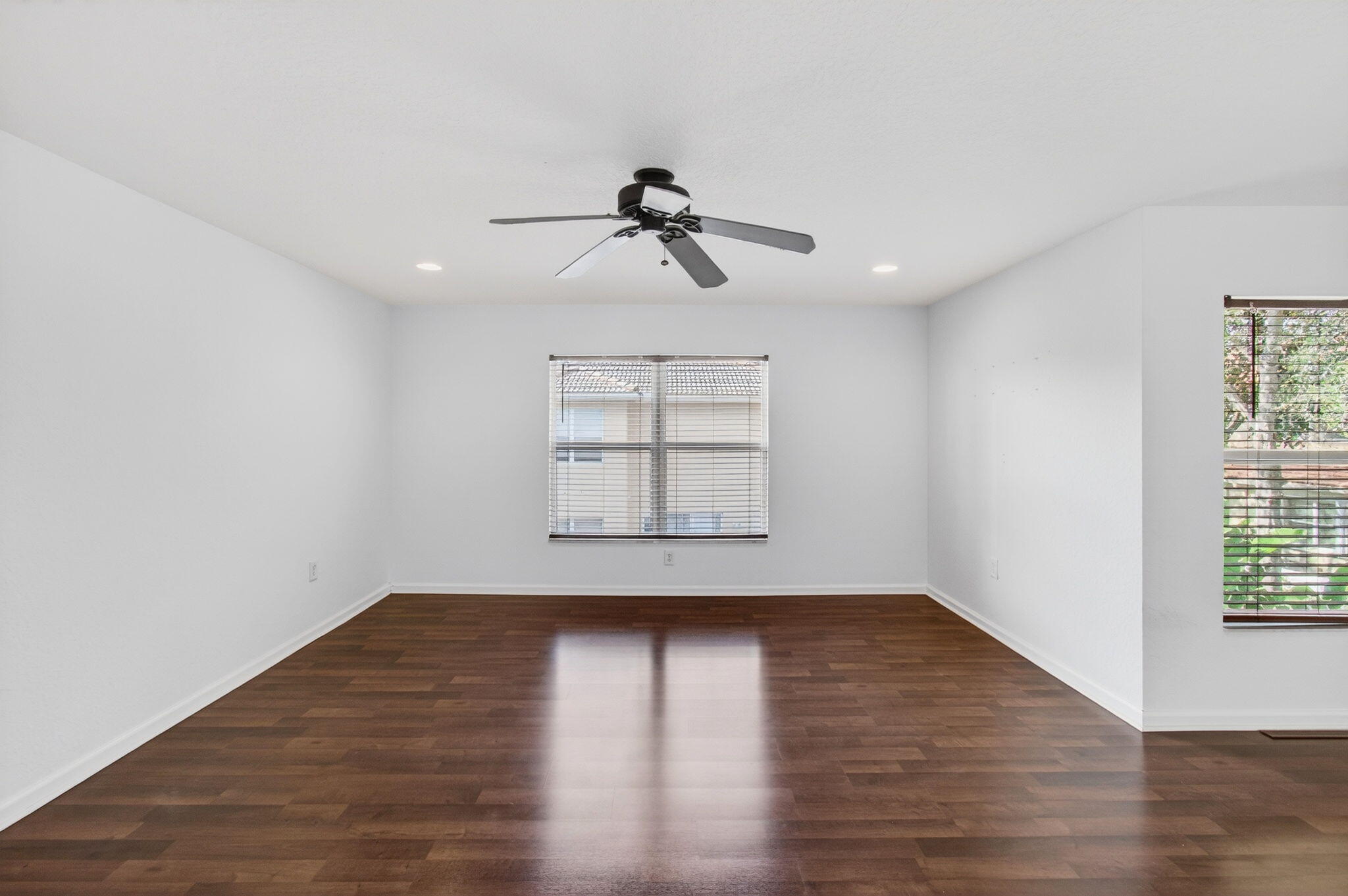 7533 Topiary Avenue Boynton Beach, FL 33437 - Photo 58 of 90 an empty room with wooden floor ceiling fan and windows