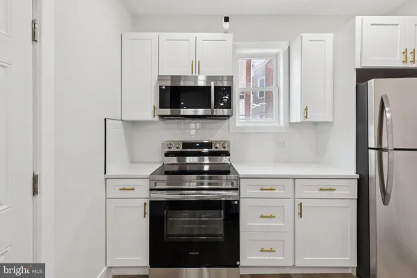a kitchen with white cabinets and stainless steel appliances