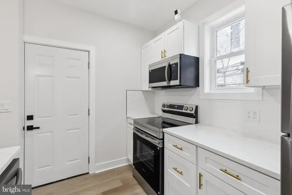 a kitchen with stainless steel appliances white cabinets and a stove top oven