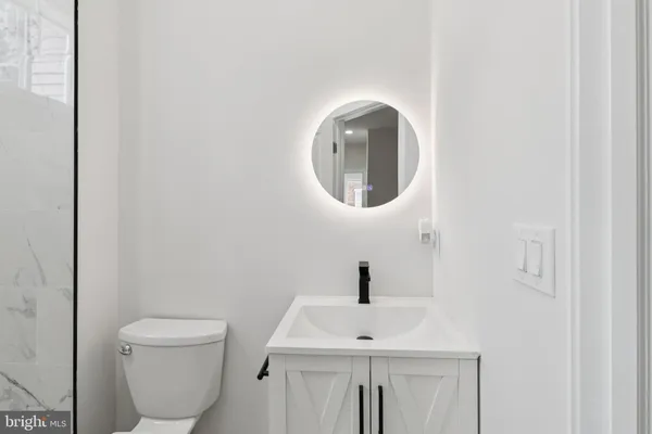 a bathroom with a toilet sink and mirror