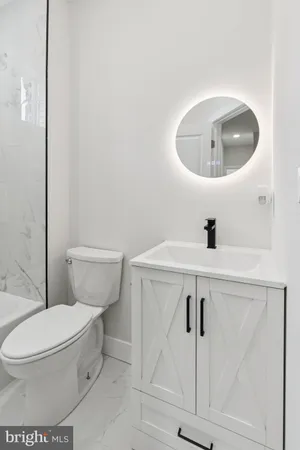 a bathroom with a toilet sink and mirror