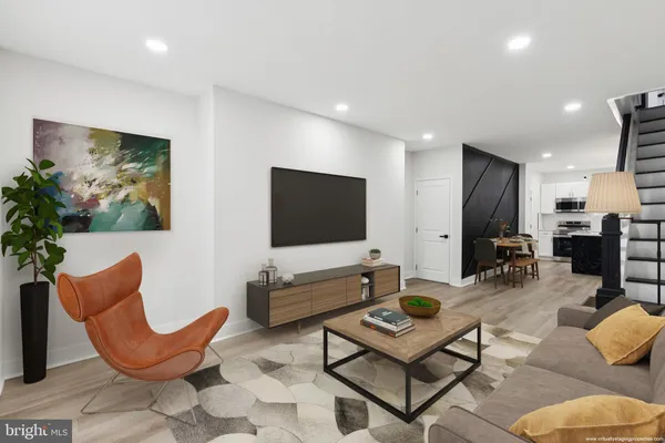 a living room with furniture kitchen view and a potted plant