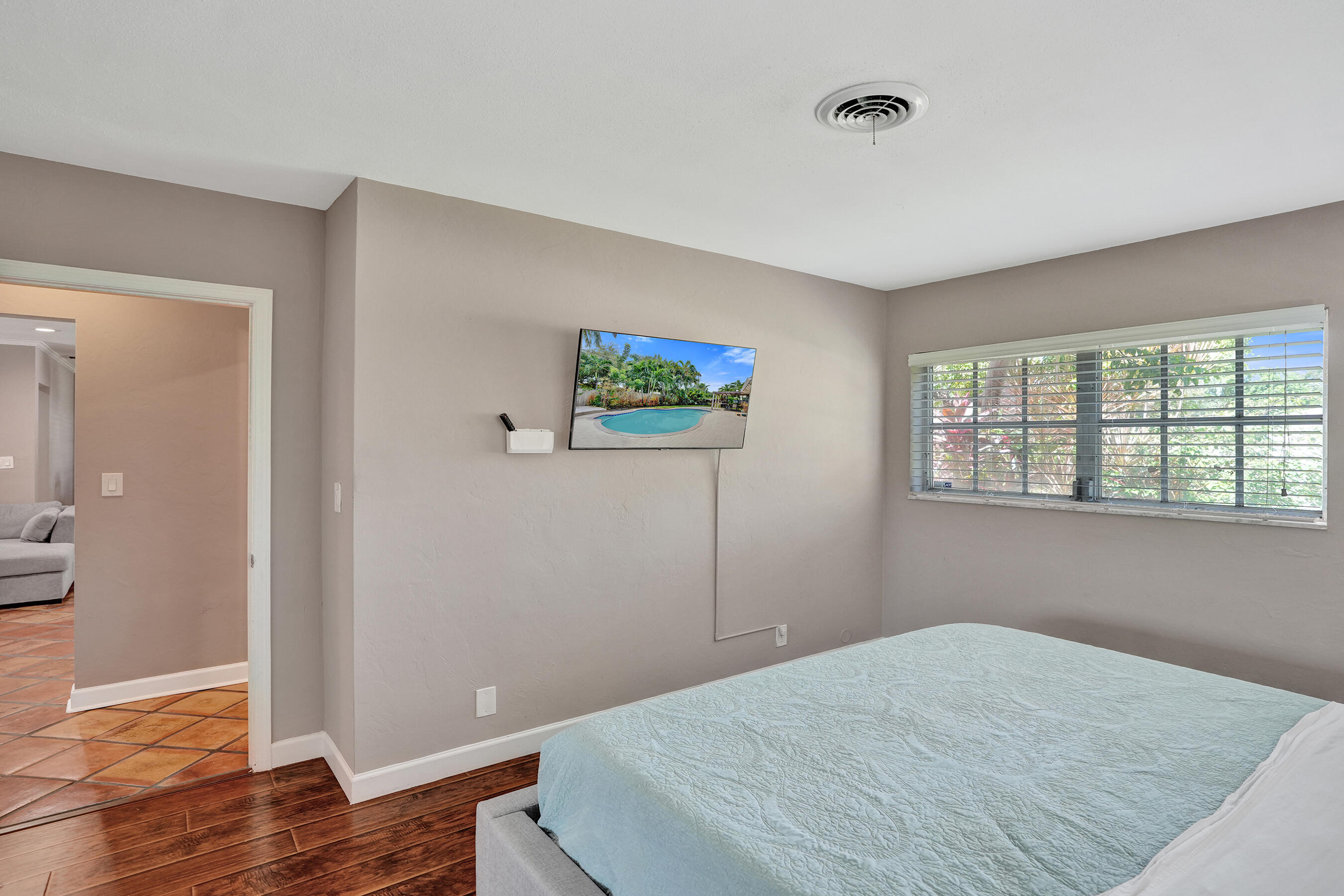 1440 Southeast 4th Court Deerfield Beach, FL 33441 - Photo 17 of 25 a bedroom with a bed and wooden floor