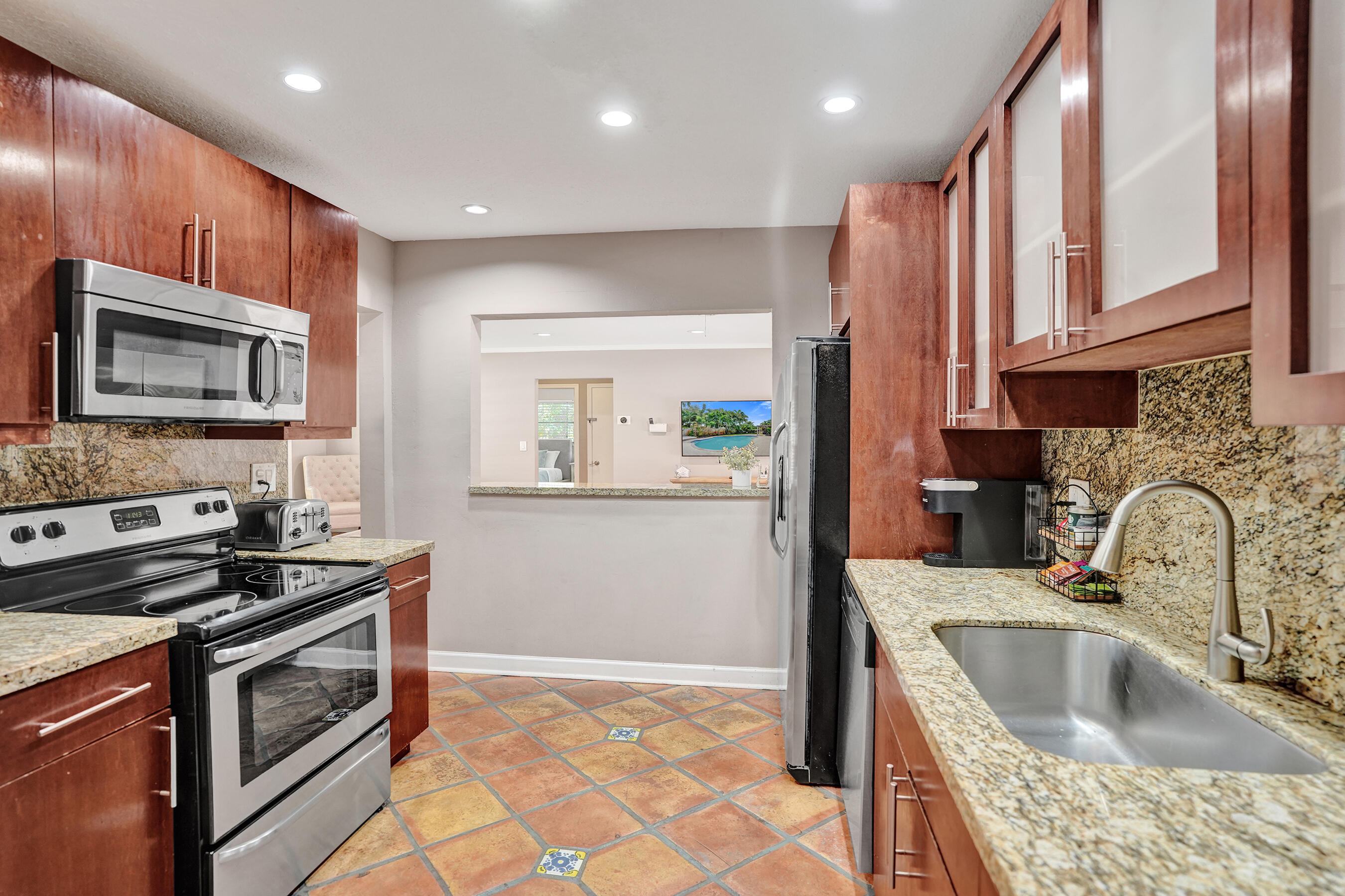 1440 Southeast 4th Court Deerfield Beach, FL 33441 - Photo 9 of 25 a kitchen that has a sink and a stove in it