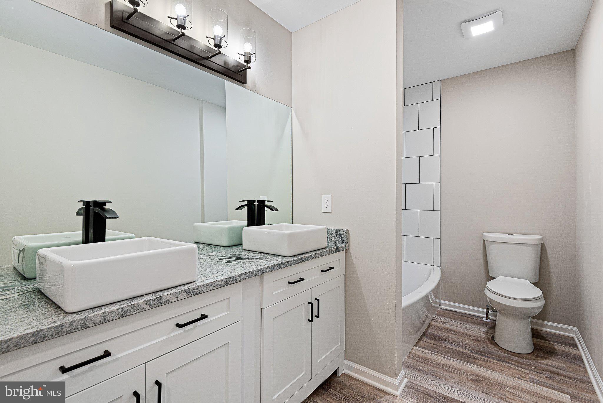 1010 Stinsford Road Newark, DE 19713 - Photo 9 of 30 a spacious bathroom with a granite countertop sink a toilet and a mirror