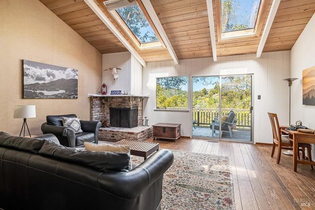 a living room with furniture a large window and a fireplace