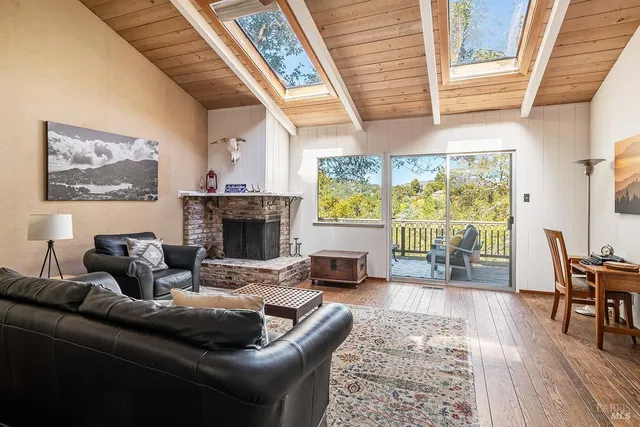 a living room with furniture a large window and a fireplace