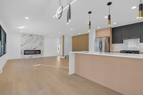 a view of kitchen with stainless steel appliances granite countertop refrigerator sink and stove