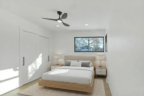 a bedroom with a large bed and a chandelier