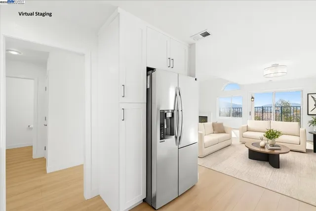 a kitchen with stainless steel appliances granite countertop a refrigerator a sink dishwasher a stove and white cabinets with wooden floor