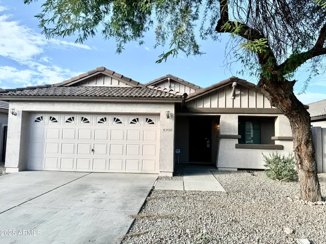 front view of a house with a yard and garage