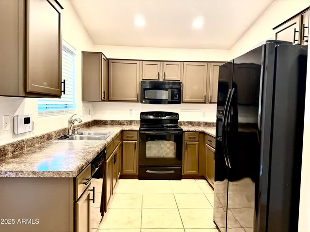 a kitchen with granite countertop a refrigerator and a sink