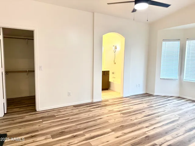 a view of a room with wooden floor and a ceiling fan