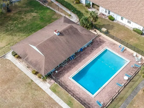 a view of a backyard with plants and chairs