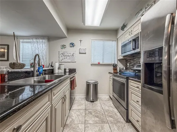 a kitchen with stainless steel appliances granite countertop a sink dishwasher and a stove with wooden floor