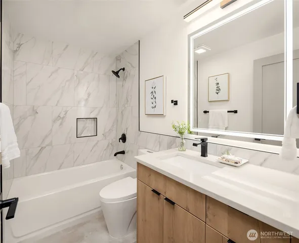 a bathroom with a granite countertop sink a toilet and bathtub