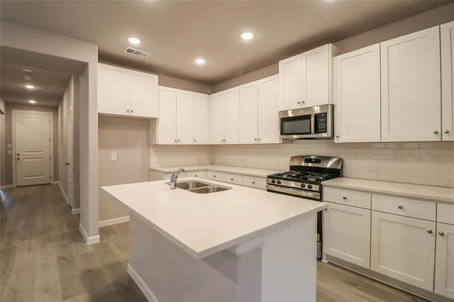 a kitchen with a sink a stove a refrigerator and cabinets